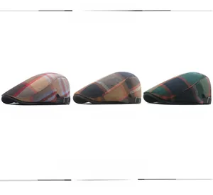 Detail view of khaki, orange, and green plaid ivy caps with metal adjustable side buckles