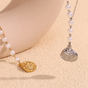 Detail of gold and silver shell pendants with small diamonds on pearl chain necklaces