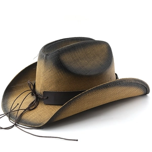 Close-up of vintage brown straw cowboy hat with distressed finish and leather strap