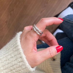Close-up of stacked 925 sterling silver rings featuring hammered and twisted textures