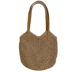Handwoven straw tote bag with brown leather shoulder straps for beach vacation