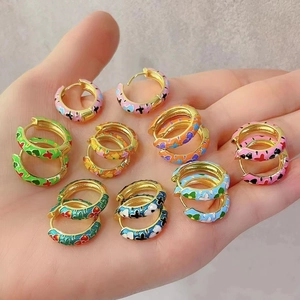Detail of colorful enamel camellia flower patterns on gold-plated C-shaped hoop earrings