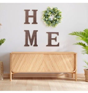 Detail of wooden HOME wall decor letters H M E with artificial eucalyptus leaf wreath