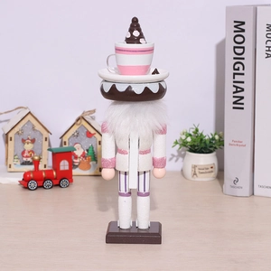 Close-up of pink wooden Nutcracker doll with a cupcake hat and donut neck decoration