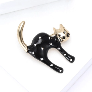 Cute black enamel cat brooch with white polka dots and gold accents on a white background