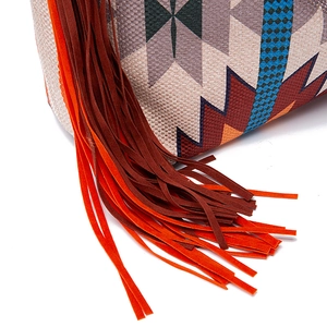 Detail of bohemian canvas shoulder bag with geometric patterns and fringe tassels