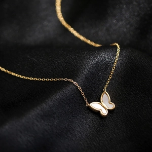 Golden butterfly necklace with white mother of pearl pendant on elegant black silk