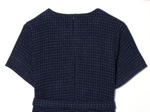 Détail d'une robe en tweed bleu marine montrant le col rond et la fermeture éclair invisible