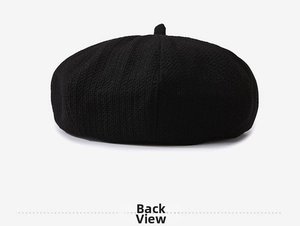 Rear view detail of black knitted beret hat showing textured weave and top stem
