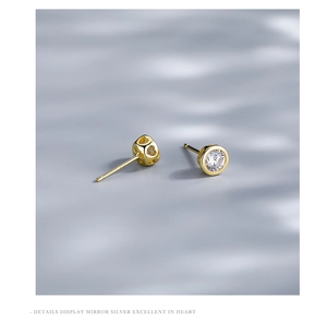 Macro detail of S925 silver gold-plated stud earring with heart cutout and zircon