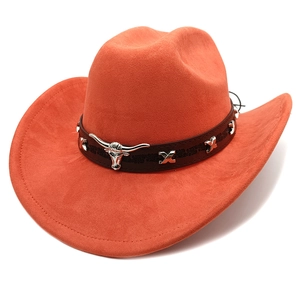 Detailed view of rust suede cowboy hat featuring metal bull skull and X-shaped studs