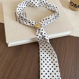 Close-up of vintage polka dot silk scarf necklace with a golden heart-shaped metal buckle