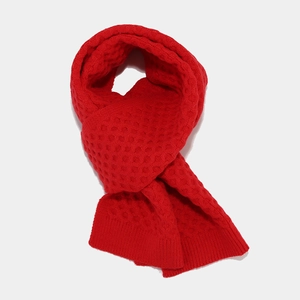 Detailed texture of red waffle knit winter scarf made of warm premium acrylic yarn