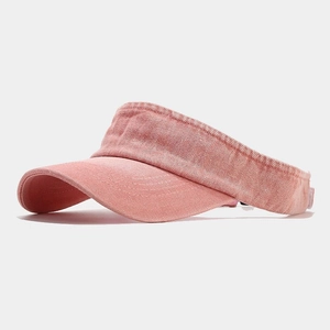 Dettaglio della trama in denim rosa lavato e della tesa curva del cappello a visiera