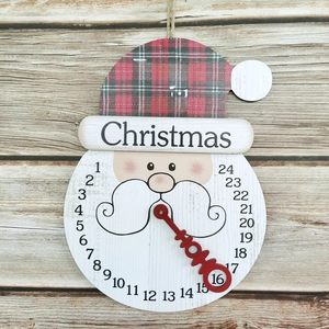 Détail d'un calendrier de l'Avent en bois avec chiffres de 1 à 24 et aiguille rouge