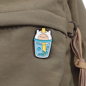 Adventure Time Finn enamel pin shaped like a bubble tea cup on a green canvas bag