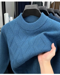 Detailopname van de blauwe gebreide trui met een klassiek ruitpatroon en dikke textuur