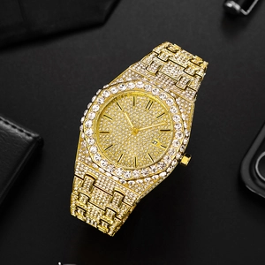 Detail of gold crystal-encrusted watch with date window on a luxury black leather surface