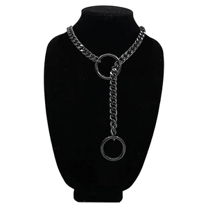 Detail of gunmetal Y-shaped Cuban chain necklace with rings on black mannequin bust