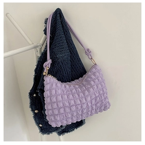 Dettaglio borsa a spalla viola con texture a bolle e anelli dorati su gruccia bianca