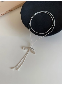 Collana a fiocco in maglia snake d'argento con ciondoli a goccia su fondo chiaro