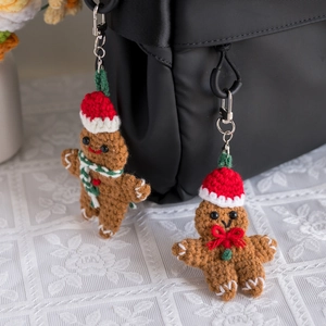 Handmade crochet gingerbread man keychains hanging on a black bag for Christmas decor