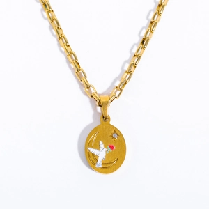 Macro shot of gold oval pendant with white dove and red flower on stainless chain