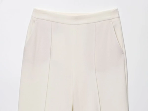 Detailaufnahme der cremefarbenen Hose mit hoher Taille, Seitentaschen und feinen Nähten