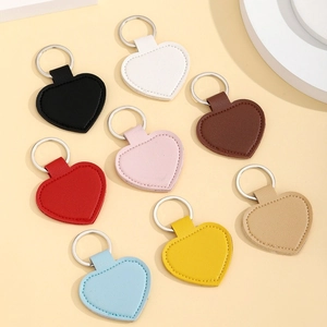 Macro shot of assorted heart-shaped PU leather keychains with neat stitching and silver rings
