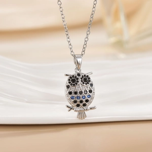Elegant owl necklace with black and blue crystals on a polished silver chain pendant