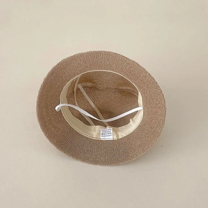 Detail view of the straw sun hat interior showing the 100% polyester label and 48cm size tag
