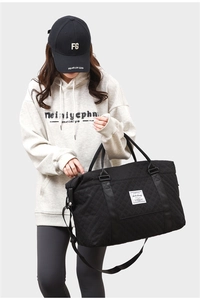 Close-up of black quilted travel bag with large capacity and durable fabric texture