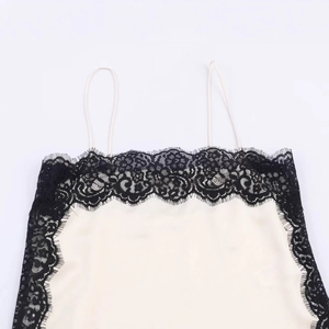 Elegant ivory satin camisole top featuring intricate black eyelash lace trim and thin straps