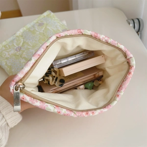 Detail shot of the floral canvas makeup bag showing internal storage capacity and lining