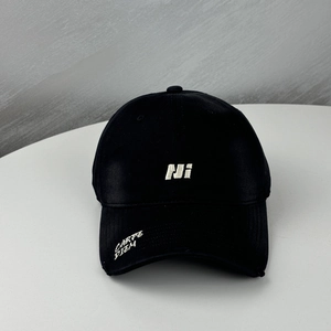 Detail of embroidered letters on a black baseball cap with curved brim and cotton texture