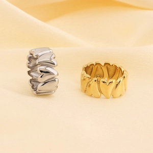Creative 18K gold and silver stainless steel heart rings on soft yellow silk background