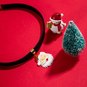 Black velvet choker necklace with Santa Claus pendant on festive red background