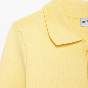 Pale yellow knit polo sweater with ribbed collar and button front detail