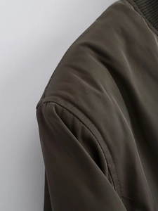 Close-up of olive green pilot jacket shoulder stitching and ribbed collar details