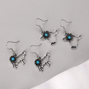 Boucles d'oreilles bohèmes tête de bœuf en argent avec perles turquoise sur fond neutre