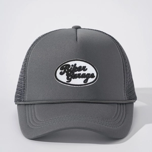 Detailed view of dark grey mesh trucker hat with Biker Garage embroidered patch