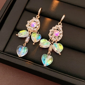 Detail view of vintage heart tassel earrings with colorful crystals in black jewelry box