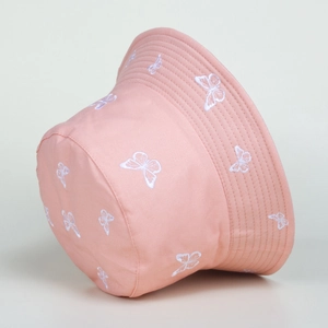 Detailed view of white butterfly embroidery on a light pink cotton bucket hat