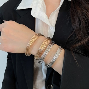 Detail of multi-layered thin stackable bangles in gold silver and rose gold finishes