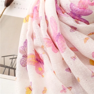 Close-up of pink scarf with butterfly prints and subtle gold glitter texture details