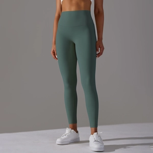 Detail of high-waisted dark green yoga leggings with seamless design on a grey background