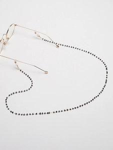 Detail of handmade gold sunglasses chain with black crystal beads and silicone loops