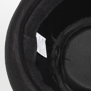 Macro view of the internal size tag and fabric material details for black jazz hat