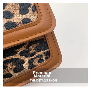 Close-up of leopard print fabric texture and brown faux leather trim stitching details