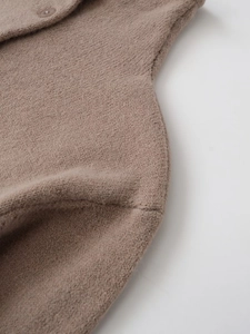 Close-up detail of coffee brown knit texture with a matching resin button on the cardigan